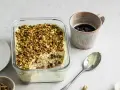 Un delizioso tiramisù al pistacchio, cosparso di granella verde, pronto per essere gustato con un caffè.