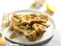 Carciofi cotti in olio e limone, pronti per essere serviti. Scopri come congelare i carciofi per averli sempre a disposizione.