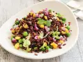 Insalata colorata con riso venere, piselli, mais, cipolla rossa e lattuga. Un'idea fresca per le tue riso venere ricette.