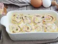 Nidi di rondine in una teglia bianca, con prosciutto, formaggio e funghi. Ingredienti per un piatto delizioso.