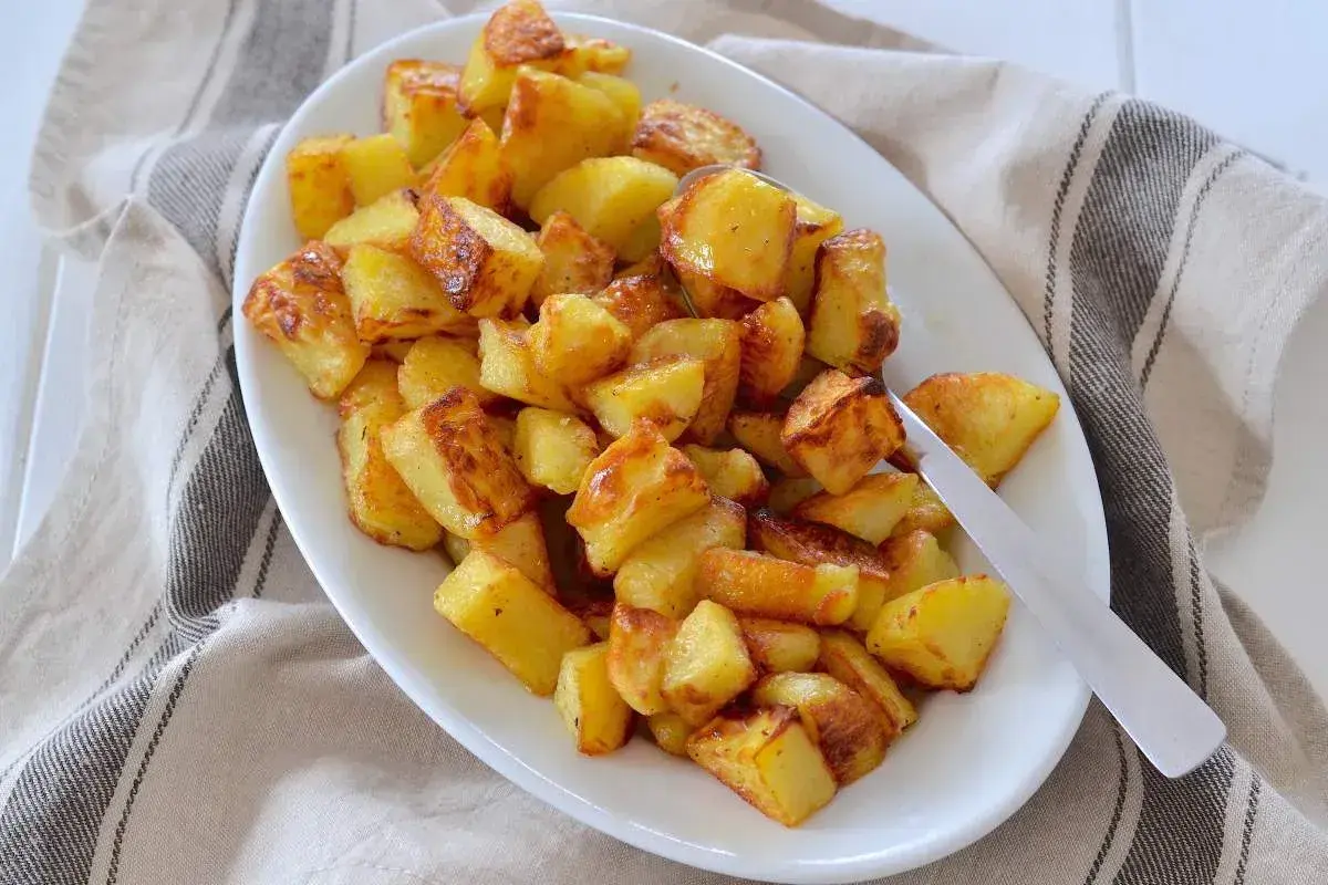 Un piatto invitante di patate al forno dorate e croccanti, pronte per essere gustate.