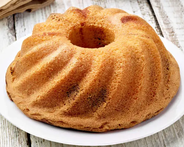 Ciambellone senza uova dorato e soffice, con la sua forma a ciambella, pronto per essere gustato.