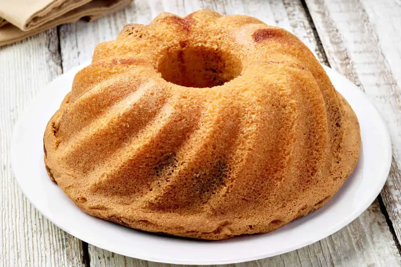 Ciambellone senza uova dorato e soffice, con la sua forma a ciambella, pronto per essere gustato.